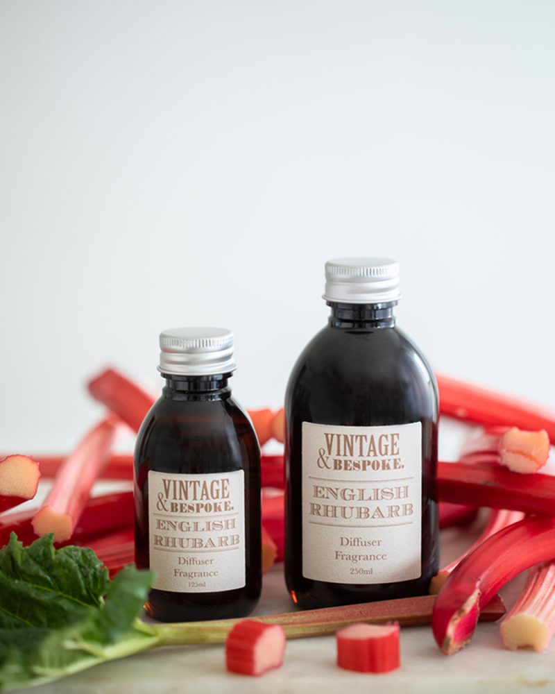 English Rhubarb diffuser fragrance bottles styled with fresh rhubarb stems on a light background
