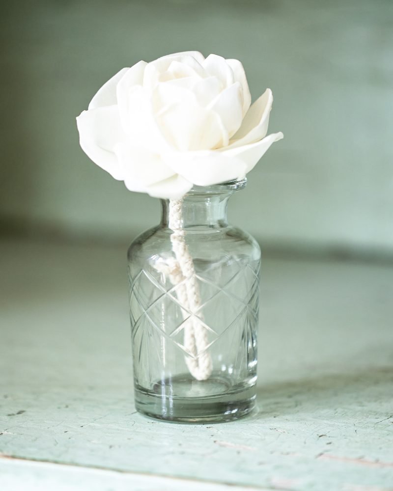 Vintage-style glass diffuser bottle with white handmade diffuser flower