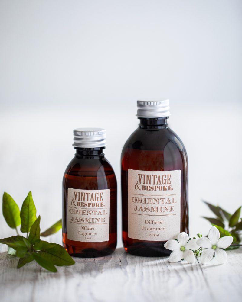 Oriental Jasmine diffuser fragrance bottles with white jasmine flowers styled on a neutral background