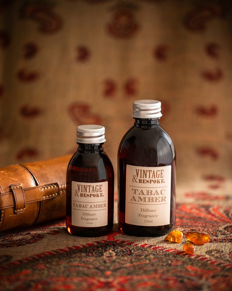Tabac Amber diffuser fragrance bottles styled with vintage leather case and warm amber tones